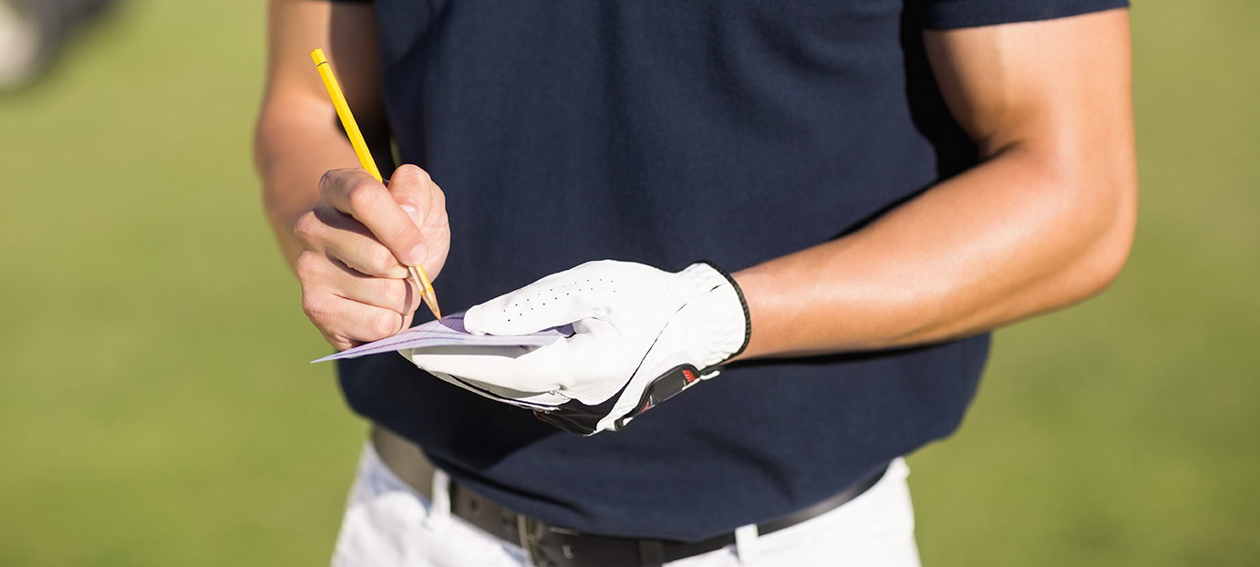 golfer writing on score card at Te Ngutu golf club